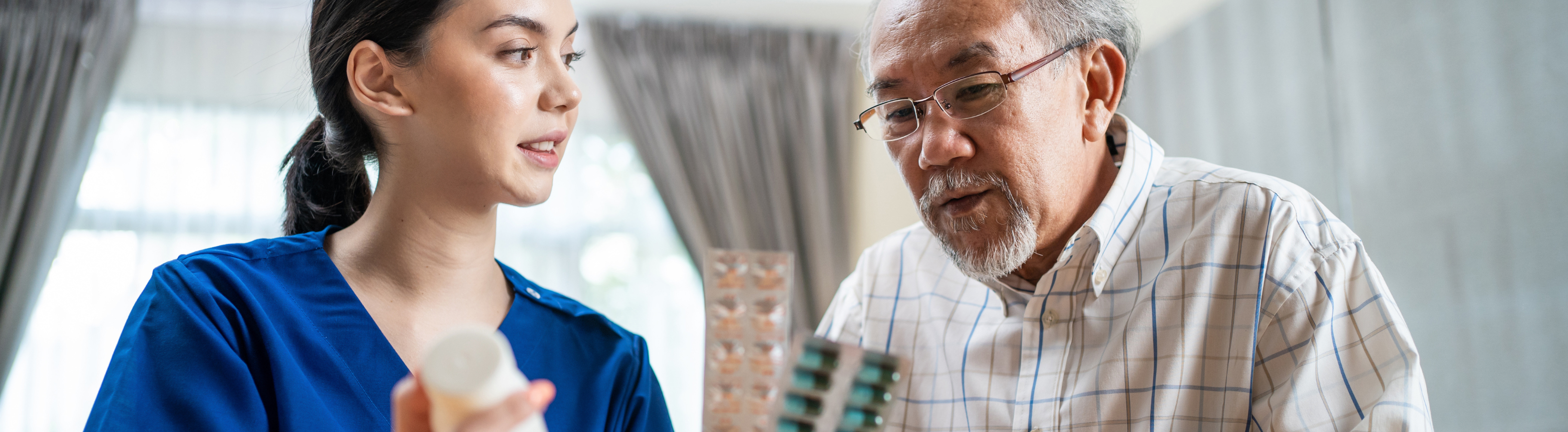 Older adult taking assistance on medication from nurse